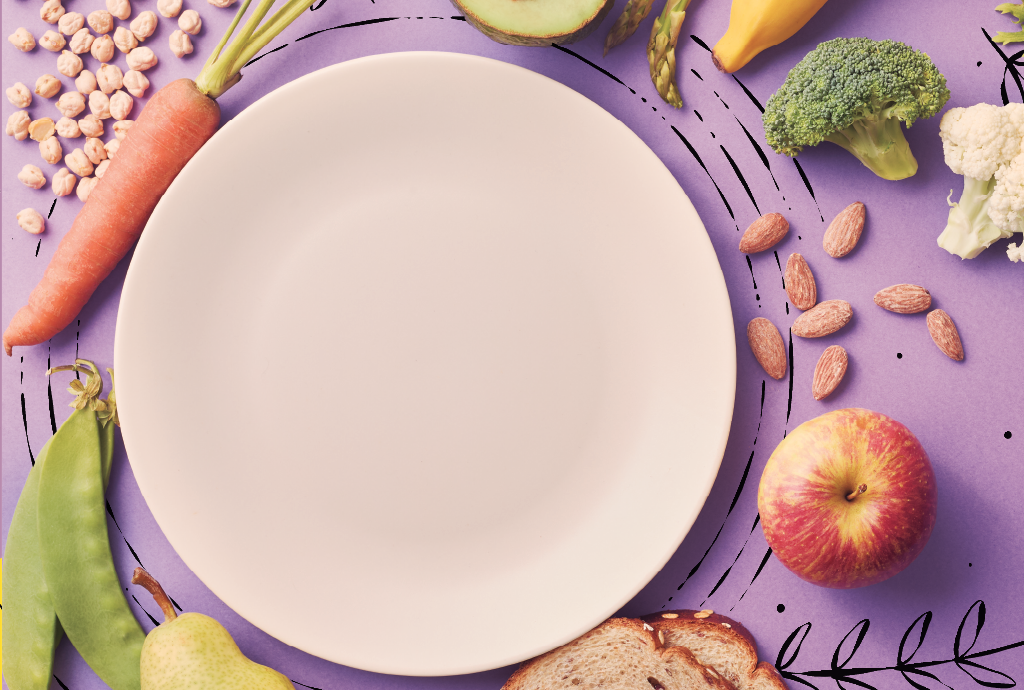 Prato branco vazio centralizado, cercado por alimentos saudáveis em fundo roxo com detalhes pretos. Há grão de bico, cenoura, ervilhas, pera, pão integral, maçã, amêndoas, brócolis, couve-flor, banana, aspargos e abacate