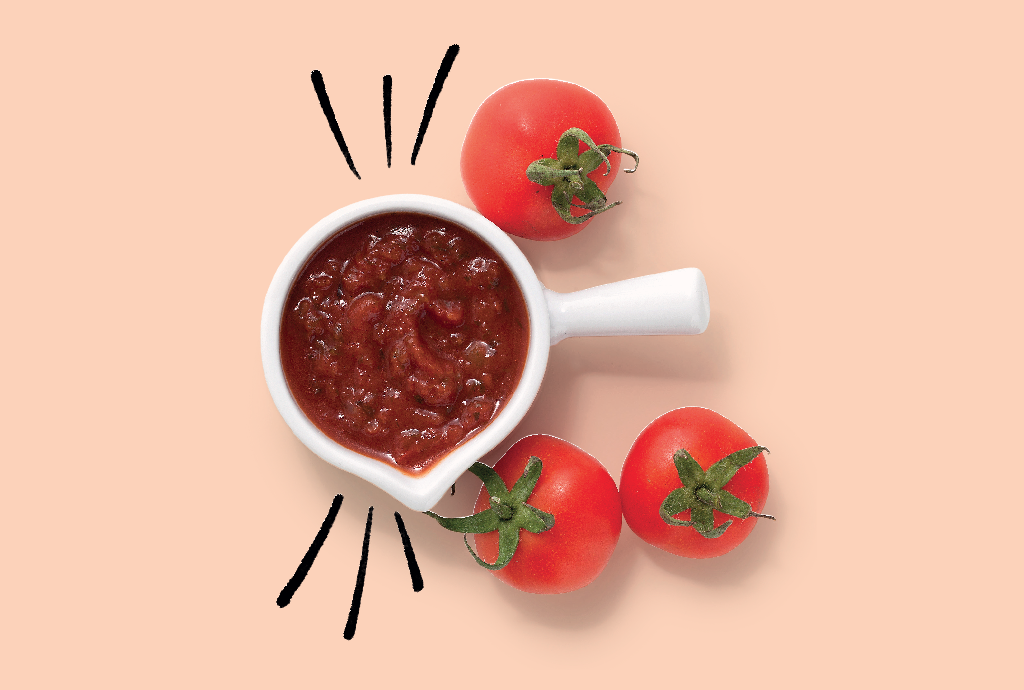 Molho de tomate caseiro em uma tigela branca com alça, cercado por três tomates frescos e maduros, sobre um fundo pêssego. Linhas pretas estilizadas irradiam do molho